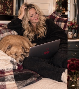Jennifer curled up at home with her dog and laptop