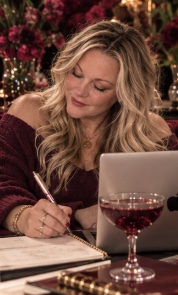 Jennifer writing ideas in a notebook beside her laptop