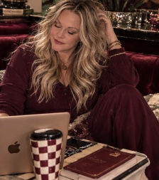 Jennifer at her laptop with a notebook and checkered mug