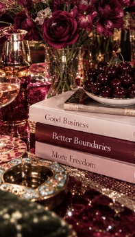 Burgundy flowers, candlelight, and books on a supper-club table